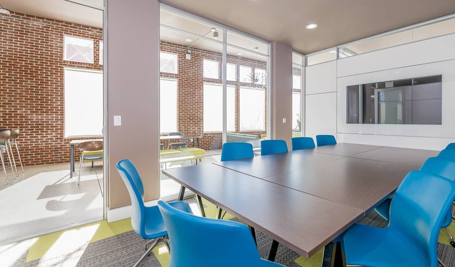 Conference room with exposed brick and blue task chairs
