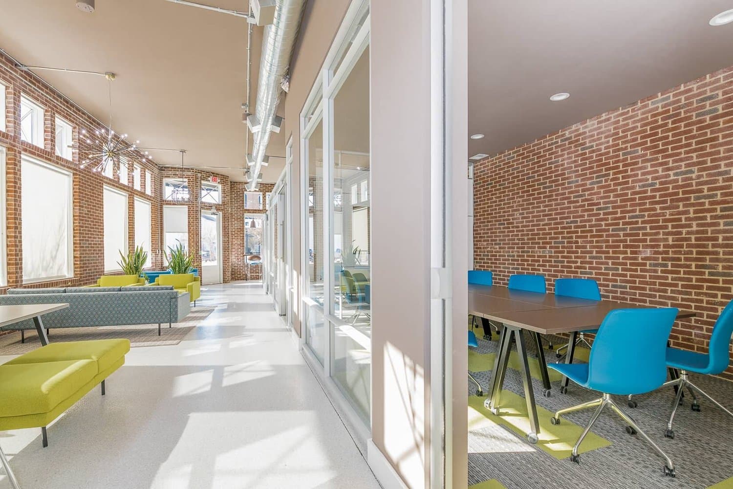 Hallway of glass offices with exposed brick