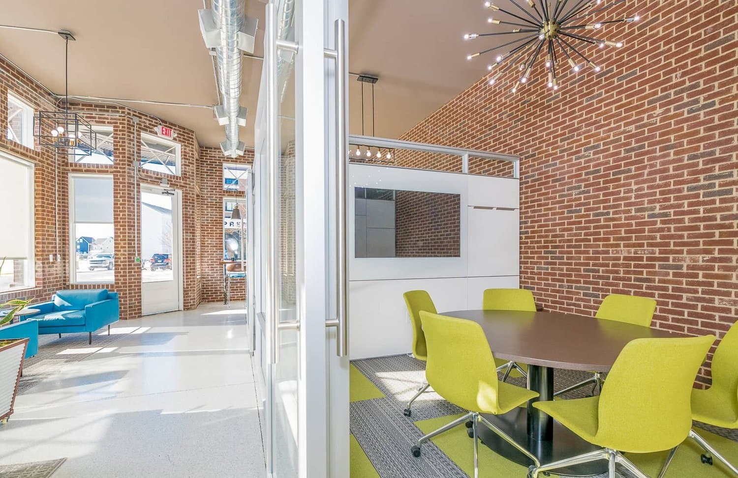 Glass-front private room with round table and lime chairs